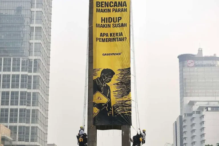 Aktivis Greenpeace Indonesia membentangkan spanduk protes di atas Patung Selamat Datang, Bundaran Hotel Indonesia (HI), Menteng, Jakarta Pusat, Selasa (20/10/2026) pagi.(Dokumentasi: Greenpeace Indonesia)